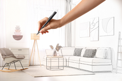Une main dessine les meubles d'une maison 
